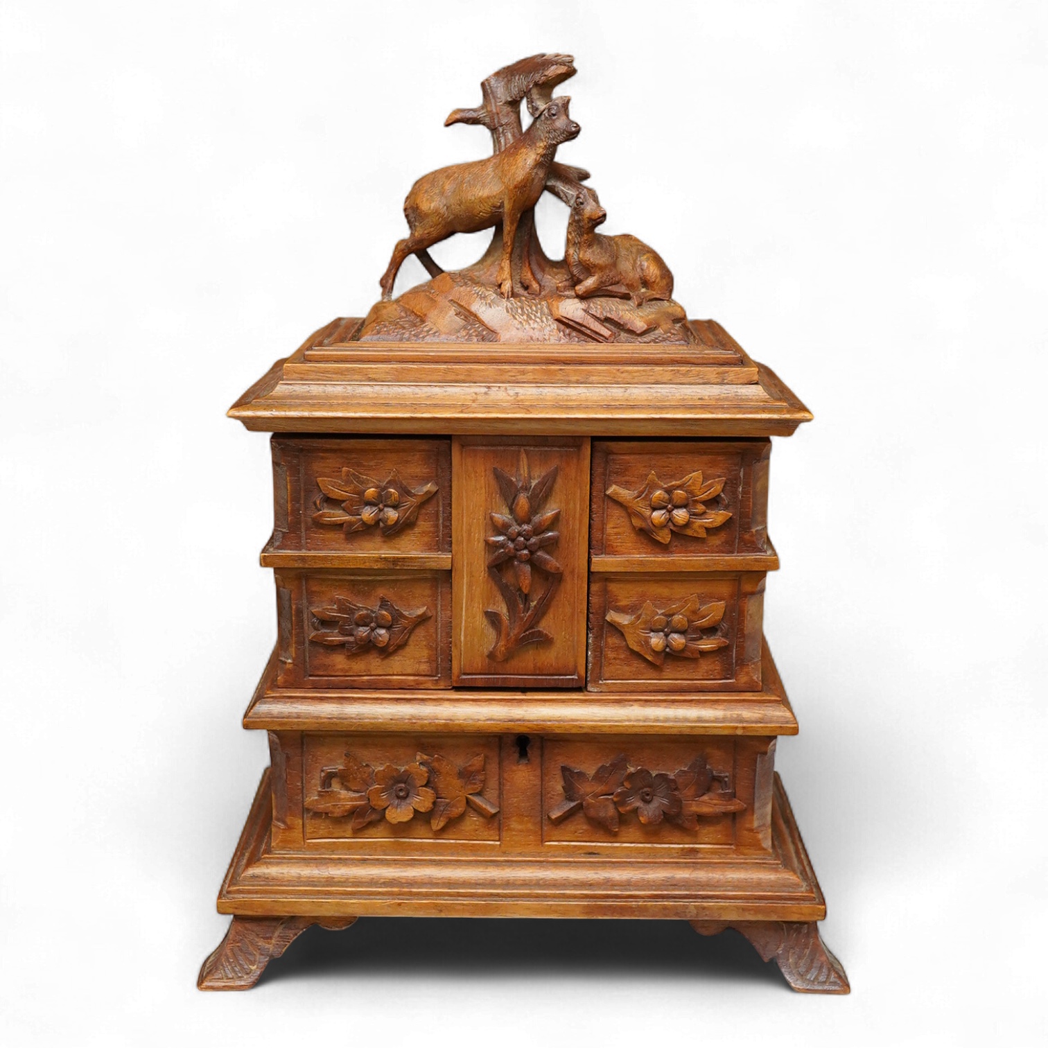 A 20th century black forest carved wood jewellery box, surmounted with two deer, 28cm high
